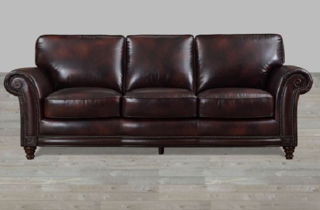 A leather sofa on a wooden floor.