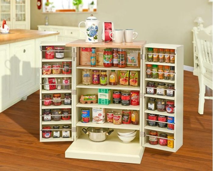 A small kitchen with a large storage cabinet full of jars.