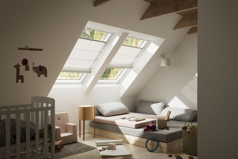 A child's room with a bed, a crib, and a window. (Keywords: window)