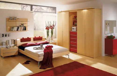 Spruce up your bedroom with a red rug and wooden furniture.