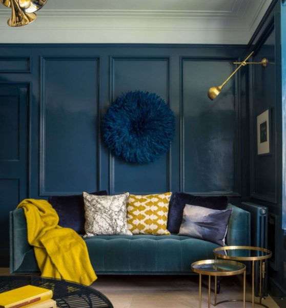 A living room with blue walls and gold accents, showcasing beautiful room colors.