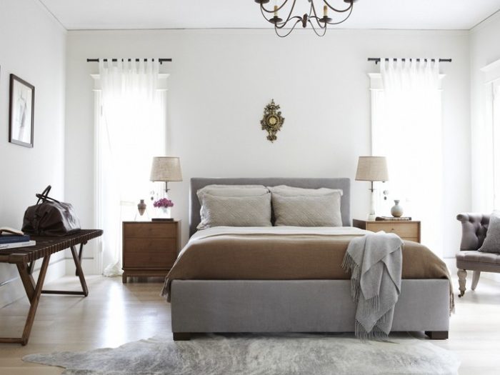 A bedroom with white walls and a gray cowhide rug, perfect for buying a mattress.