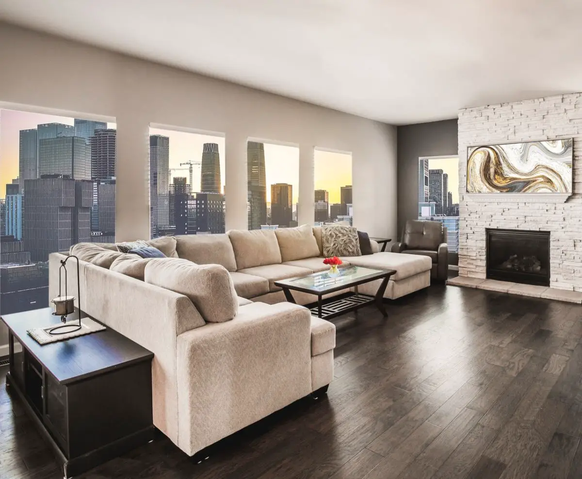 A spacious living room with hardwood floors and a stunning view of the city.