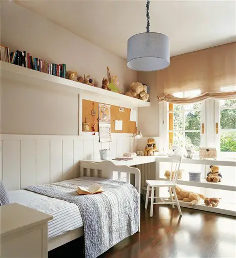 A homey child's room with a bed, desk, and teddy bears.