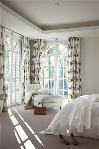 A home with a white bed and white curtains.