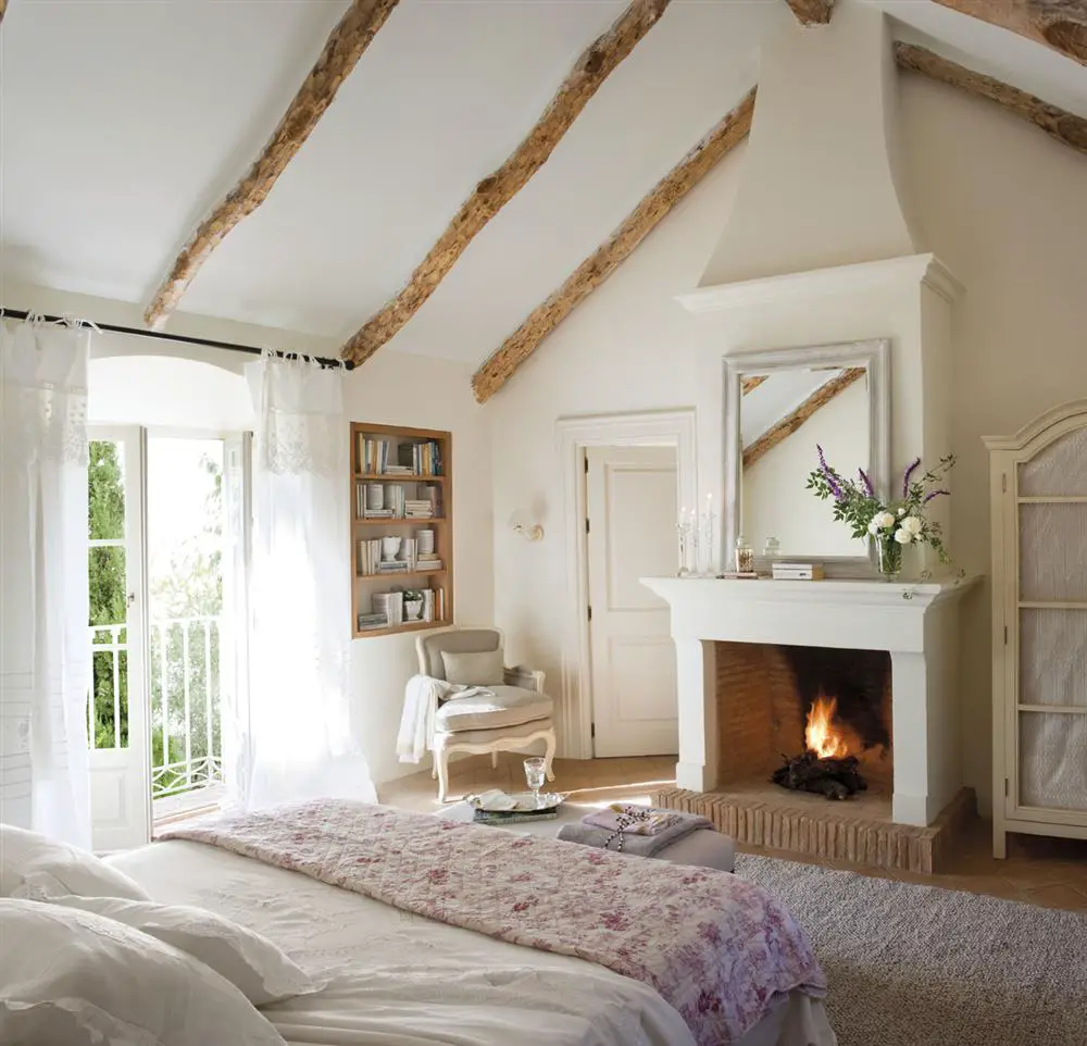 A white bedroom with wooden beams and curtains.