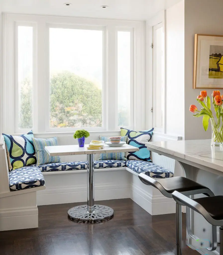 An ideal kitchen with a window seat and bar stools.