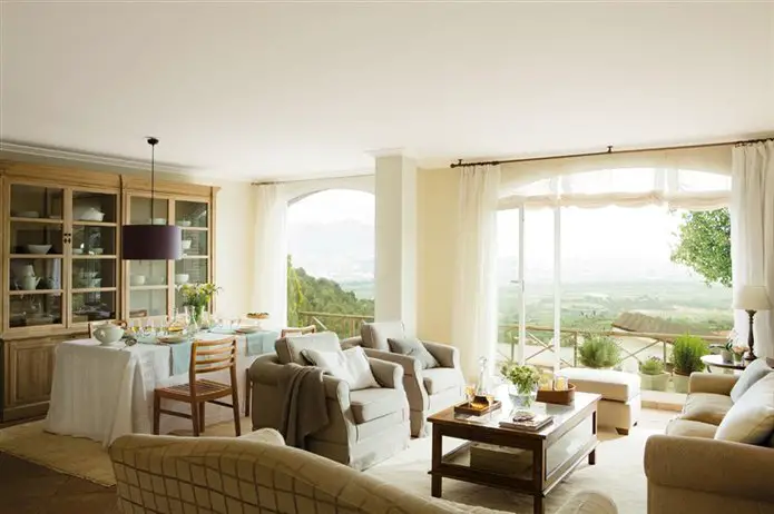 A renovated living room with large windows overlooking the countryside.