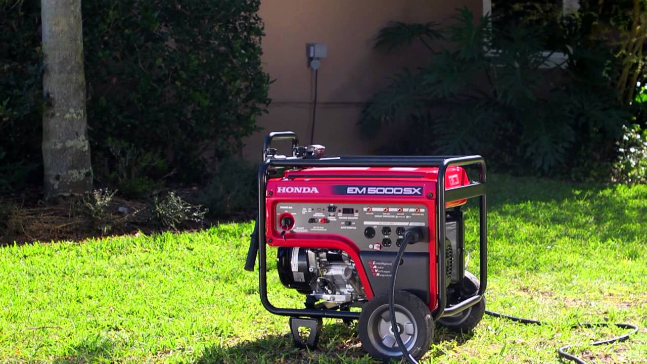 A red power generator sits on the grass in front of a house.