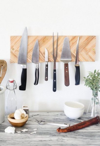 A knife rack designed for kitchen space with knives hanging on it.
