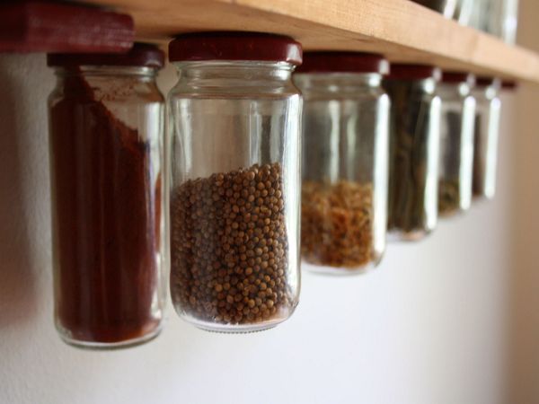 Jars of spices hanging in a kitchen space.
