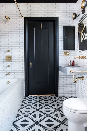 A bathroom with black and white tiled floor and furniture.