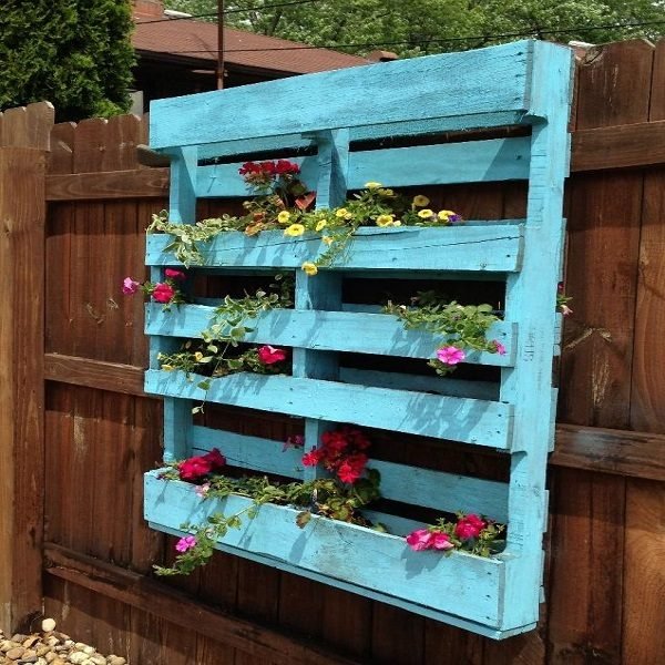 A pallet planter with flowers on it.