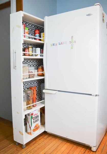 A white refrigerator with an open door in a kitchen space.
