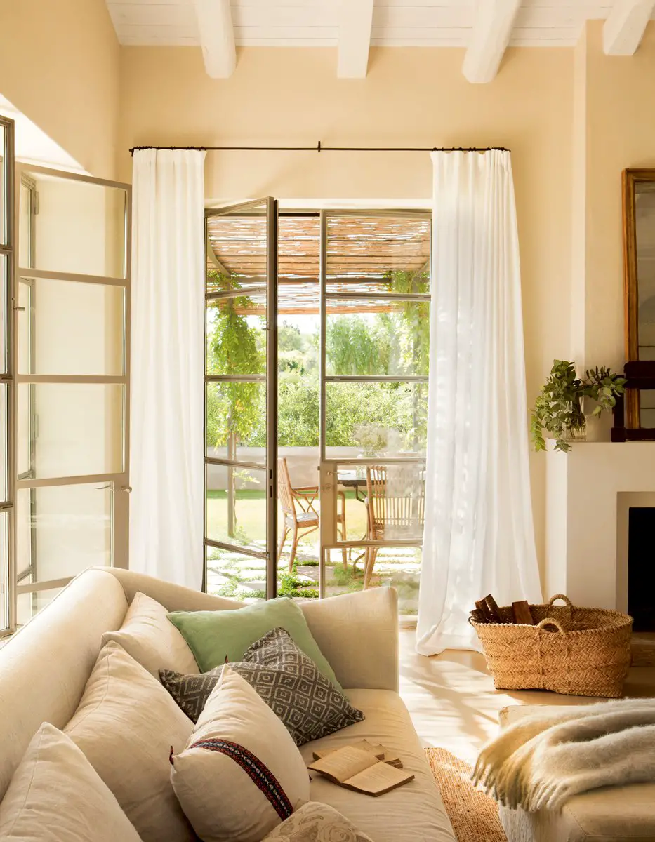 A living room with a white couch and curtains.