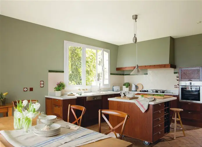 Renovation of a kitchen with green walls and wooden floors.