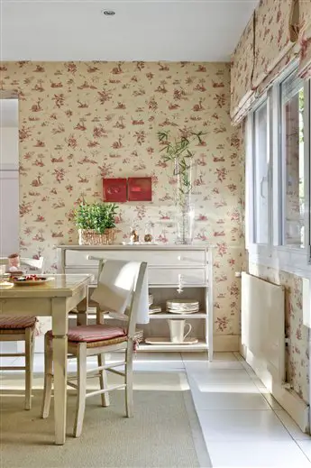 A home dining room with red and white floral wallpaper.