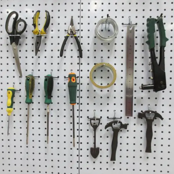 A clever garage organization idea featuring a pegboard with a variety of tools hanging on it.