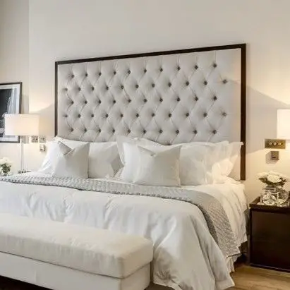 A bed with a tufted headboard.