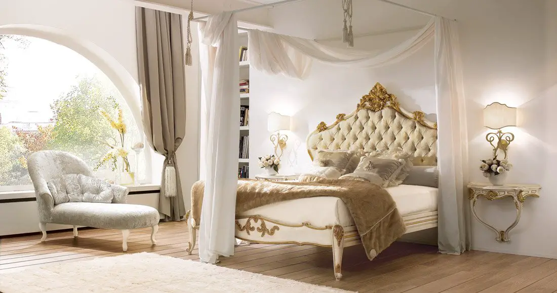 A bedroom with a white canopy bed.