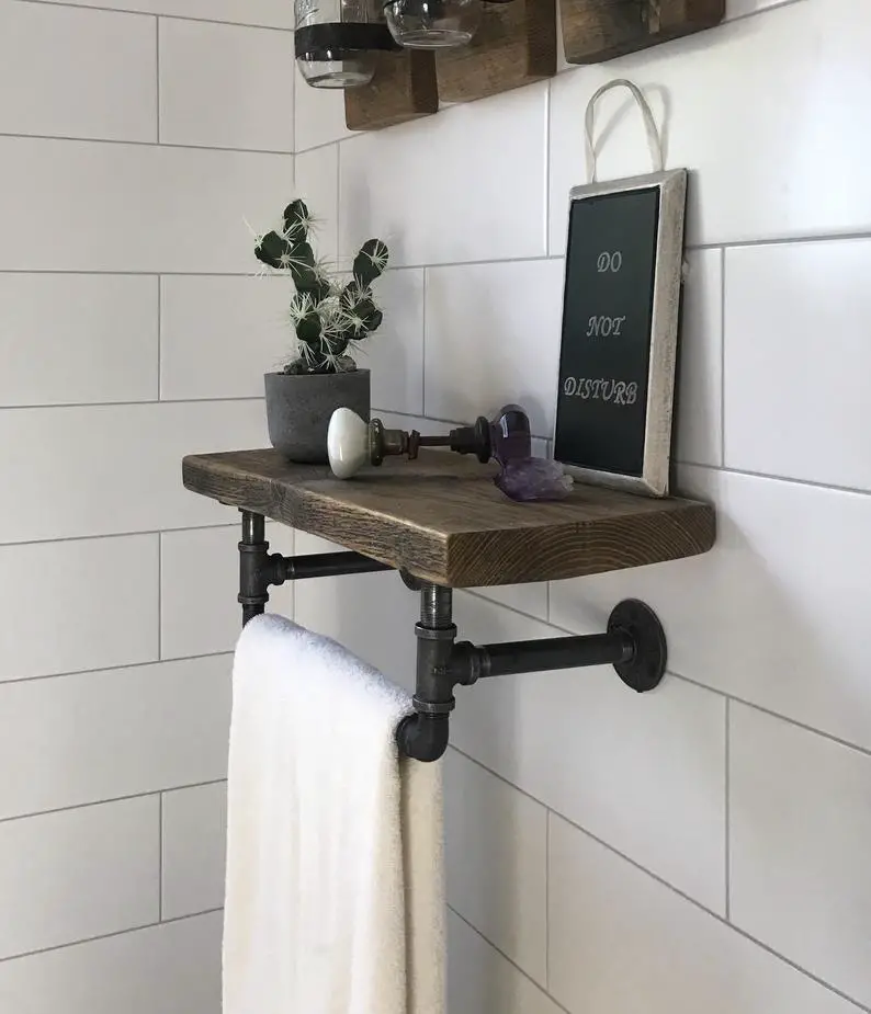 A wooden bathroom shelf with a plant.