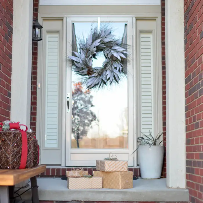 A boho chic Christmas wreath on the front door of a home.