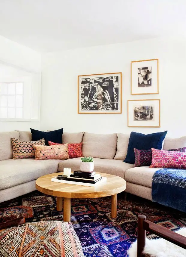 A boho chic living room with a sectional couch and a rug.