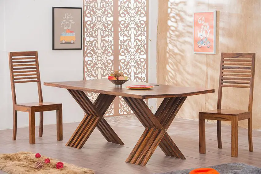 A dining table and chairs made of different types of wood in a room.