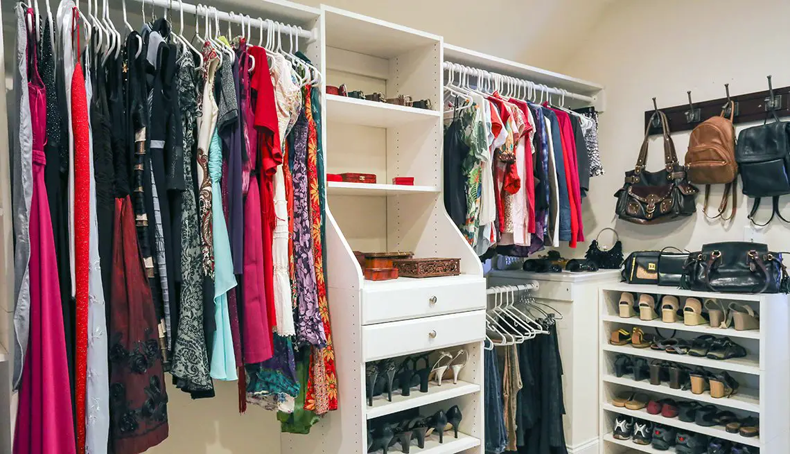 A house with a closet full of clothes, shoes and purses.