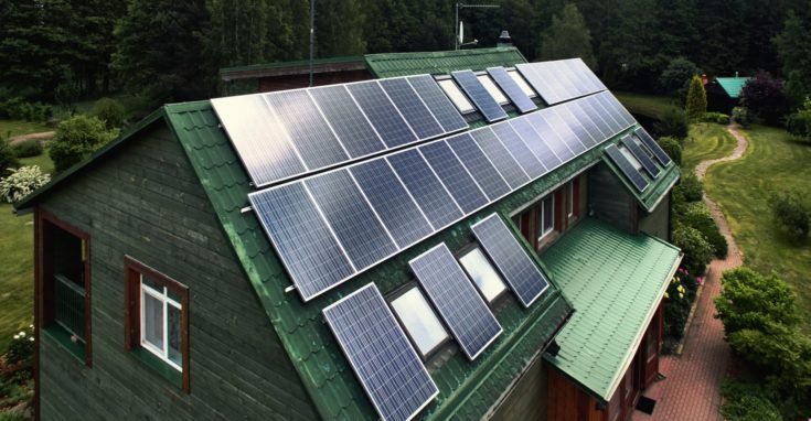 An aerial view of an environmentally friendly house with solar panels on the roof.