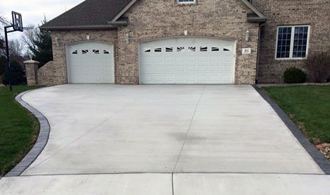 A house with a driveway and two garages, highlighting the benefits of concrete.