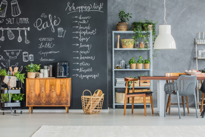 A dining room with a chalkboard wall painted with unique paints.