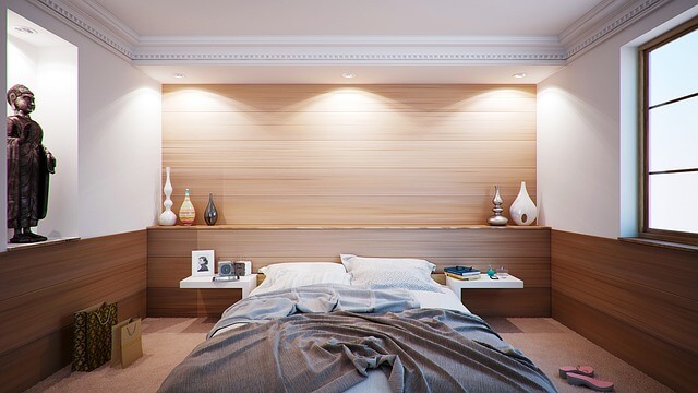 A wooden-walled bedroom with a bed.