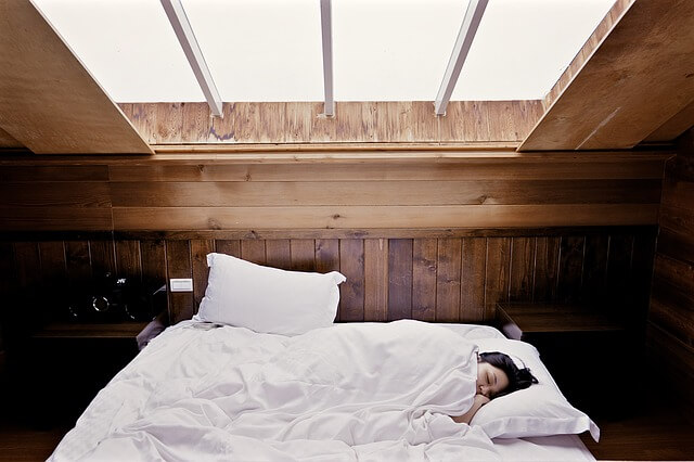 A woman sleeping in a bedroom.