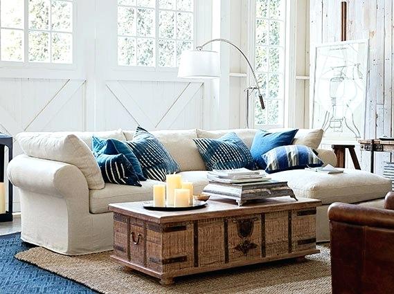 A living room with trendy decor featuring a white couch and blue rug.