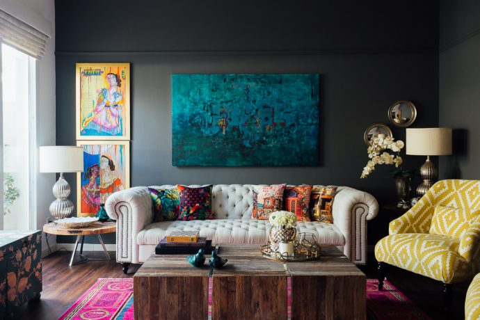 A living room with trendy decor featuring colorful rugs and paintings.