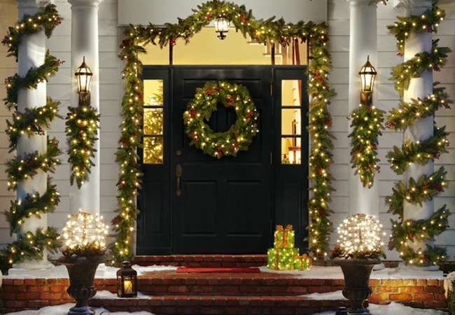 A front porch adorned with Christmas lights and garlands showcasing Christmas curb appeal.