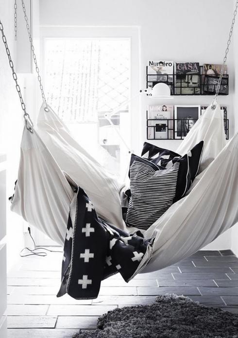 A black and white hammock hanging in a room designed for napping.