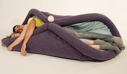 A couple napping on a purple sleeping bag.