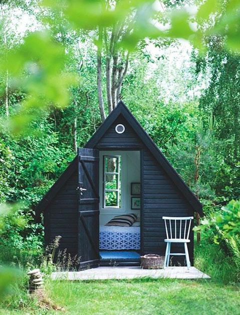 A small black cabin in the woods, perfect for finding nap corners.