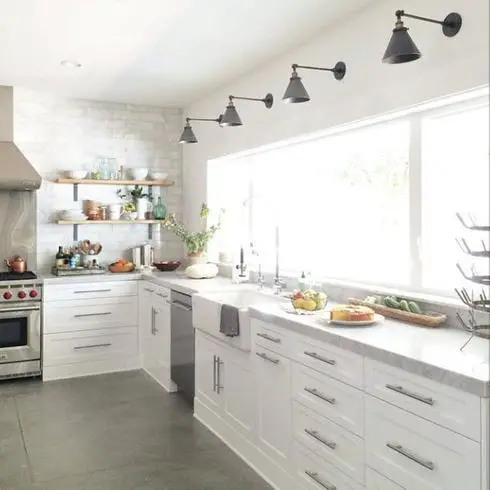 A white kitchen with stainless steel appliances that illuminate your rooms.
