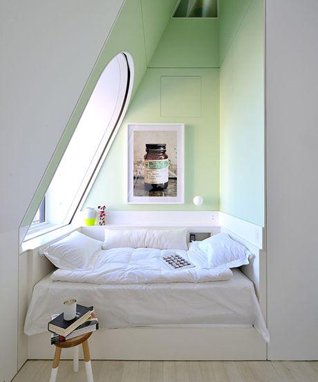 A cozy white bed with nap corners in an attic.