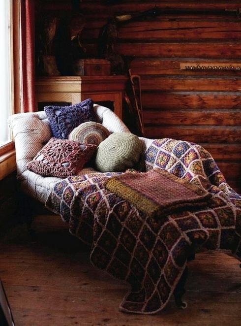 A cozy bed in a log cabin with pillows and blankets, perfect for nap corners.