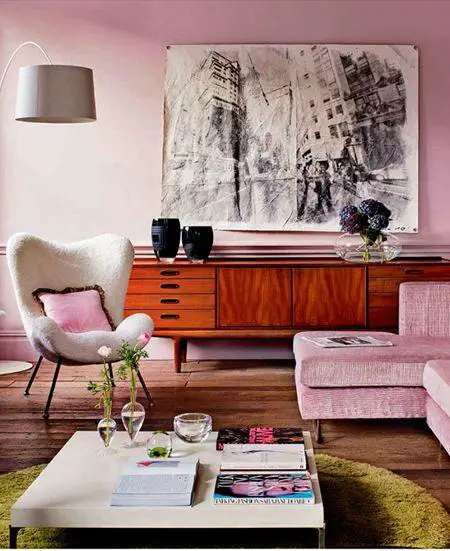 A vintage living room with pink walls and furniture.