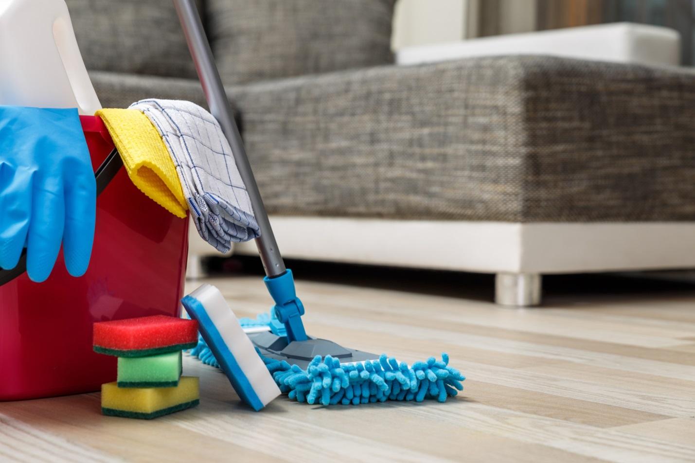A mop on a wooden floor during deep cleaning.