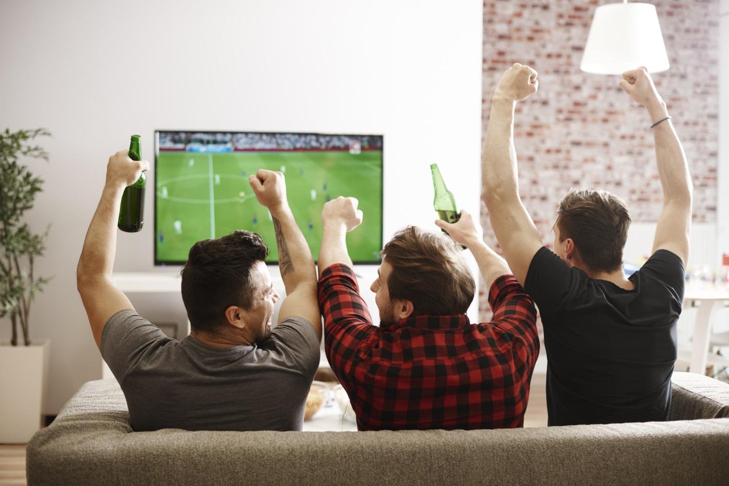 A group of friends watching a cool soccer game on tv.