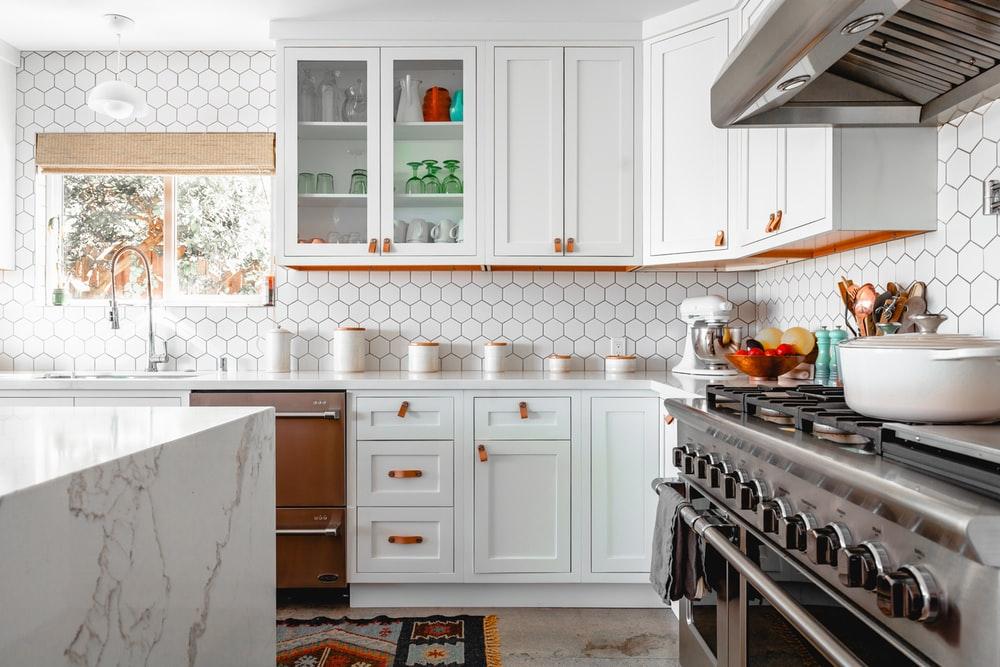 Kitchen features white cabinets.