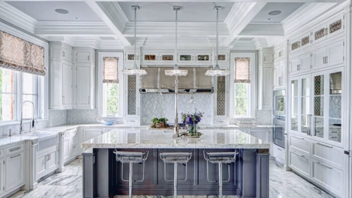 Kitchen ideas: A white kitchen with marble counter tops and a center island.