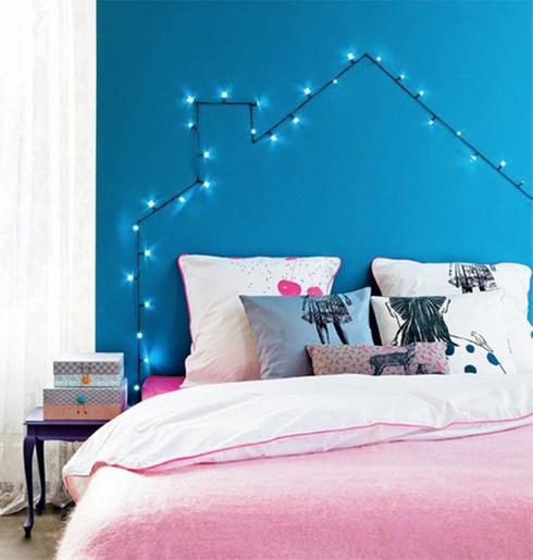 A bedroom with pink and blue lights on the wall.