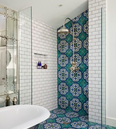 A tiled bathroom with a tub and shower in blue and green.